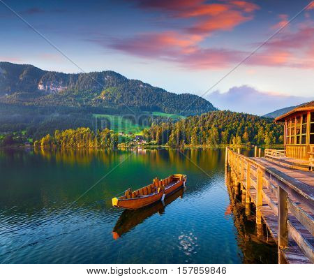Colorful summer scene on the Grundlsee lake. Pier on Archkogl village with small pleasure launch. Alps Austria Europe.