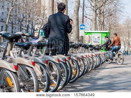 Paris France - April 02 2009: Young man depositing his bike at the Velib station public bicycle rental in Paris. Velib has the highest market penetration comapring to other cities.