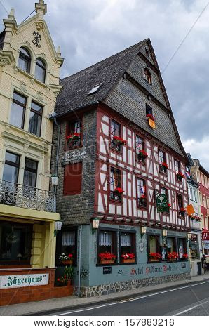 Sankt Goar, Germany - July 8, 2011: Houses on Rhine embankment in medieval village of Sankt Goar with Rheinfels Castle Germany. Rhine Valley is UNESCO World Heritage Site.