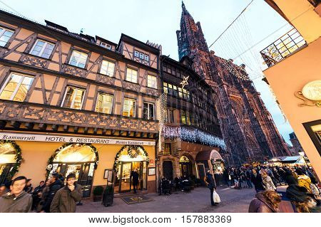 STRASBOURG FRANCE - DEC 06 2015: Place de la Cathedralee with impressiove view over hte Notre-Dame cathedrale of Strasbourg and Hotel and Restaurant Kammerzell House in central Strasbourg during Christmas Holidays Market Noel