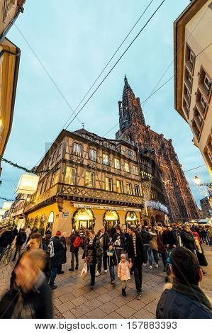 STRASBOURG FRANCE - DEC 06 2015: Place de la Cathedralee with impressiove view over hte Notre-Dame cathedrale of Strasbourg and Kammerzell House in central Strasbourg during Christmas Holidays Market Noel
