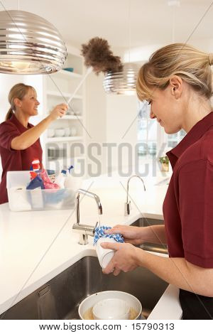 Tým komerční čističe pracují v domácí kuchyni