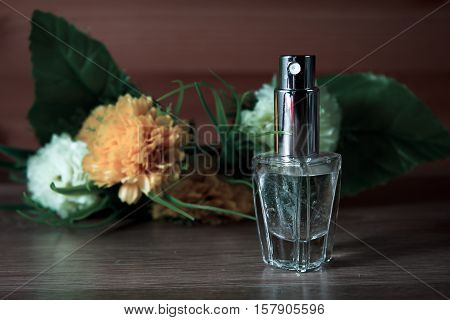 female perfume and flowers in wooden background