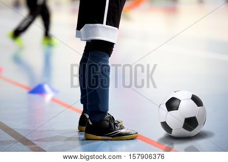 Football futsal training session. Futsal player with soccer ball. Indoor soccer young player with a soccer ball in a sports hall. Sport background