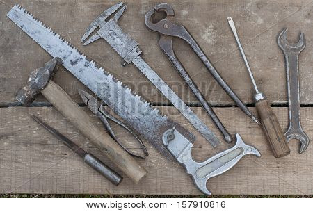 A collection of old rusty tools. Carpentry, hammer, knife, saw, scissor, worn