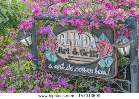 OLINDA, BRAZIL, JANUARY - 2016 - Detail view of crafted decorated restaurant banner post surrounded by flowers at Olinda town Pernambuco Brazil