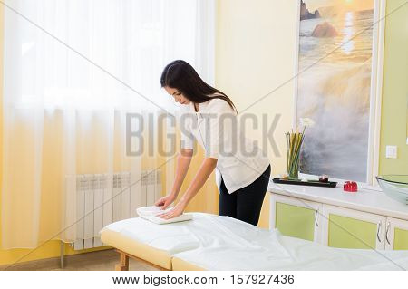 Professional massage therapist preparing the area for treatment.