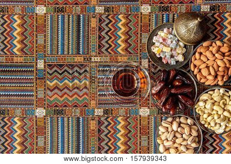 sweets, dates and tea on a traditional Arabian carpet
