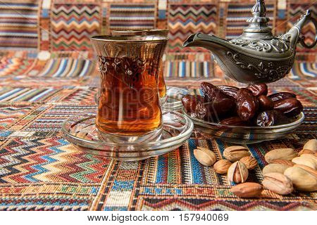 sweets, dates and tea on a traditional Arabian carpet
