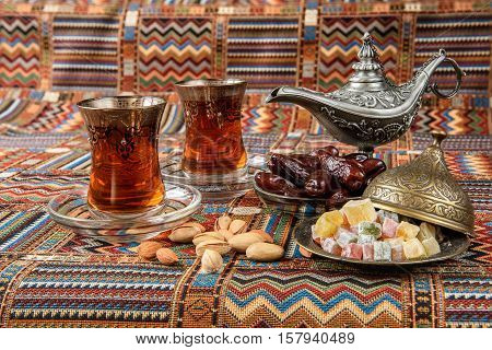 sweets, dates and tea on a traditional Arabian carpet