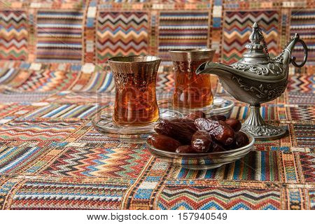 sweets, dates and tea on a traditional Arabian carpet