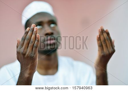 African Muslim Man Making Traditional Praying To God While Wearing A Traditional Cap Dishdasha