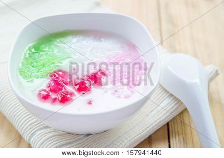 Tub Tim Krob ,Stuffed Water Chestnut in Syrup and Coconut Milk on wood table thailand dessert.