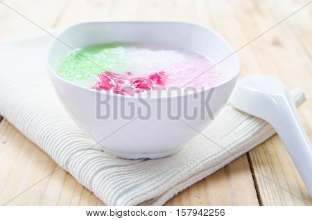 Tub Tim Krob ,Stuffed Water Chestnut in Syrup and Coconut Milk on wood table thailand dessert.