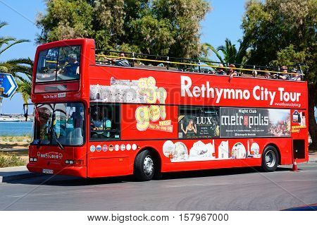 RETHYMNO, CRETE - SEPTEMBER 15, 2016 - Tourists aboard a red open topped Rethymno City Tour bus Rethymno Crete Greece Europe, September 15, 2016.