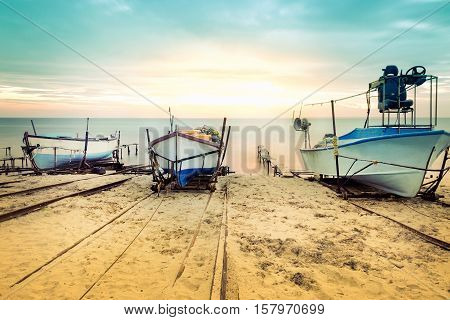 Old fishing boats laid over the sea shore. Colorful sunset above the sandy beach in Ravda Bulgaria.