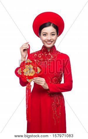 Portrait of a beautiful Asian woman on traditional festival costume Ao Dai holding Hoa Mai tree (Ochna Integerrima) flower. Tet holiday. Lunar New Year.