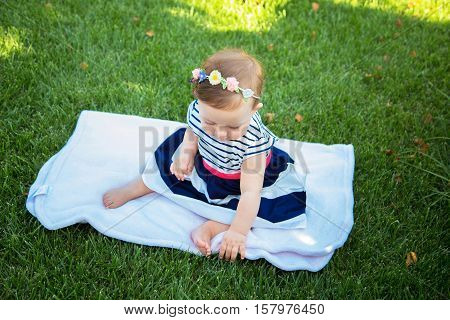 Beautiful baby girl on the green grass. Happy childhood
