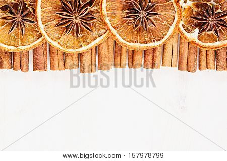 Christmas food - mulled wine background. Decorative frame of spice ingredients - anise stars cinnamon dried oranges and wine on wood white surface. Top view.