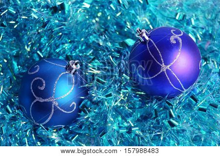 Photo by turquoise and violet christmas balls on the blue tinsel.