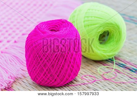 balls of pink and green knitting yarn