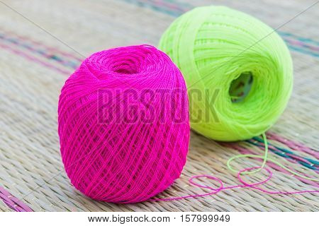balls of pink and green knitting yarn
