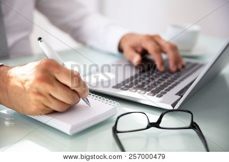Businessman's Hand Writing In Diary