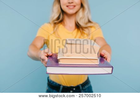 Cropped Image Of Girl Showing Books Isolated On Blue