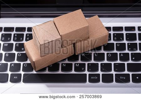 Close-up Of Small Cardboard Boxes On Laptop Keypad