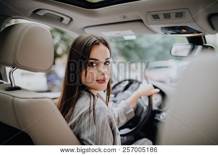 Woman In Car Indoor Keeps Wheel Turning Around Smiling Looking At Passengers In Back Seat Idea Taxi 