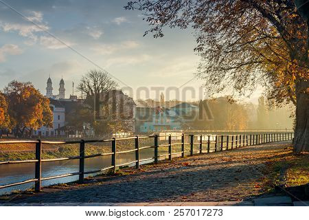 Embankment Of The River Uzh. Beautiful Urban Scenery With Colorful Foliage On Trees In Morning Haze.