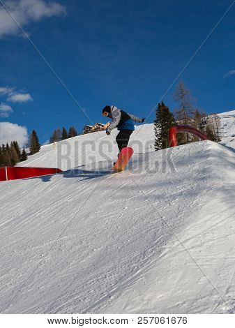 Snowboarder In Action: Jumping In The Mountain Snowpark.