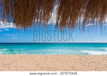 Beautiful Sand Beach With Turquoise Sea Water, Sun, Blue Sky And Straw Umbrella