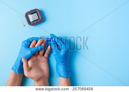 Nurse Making A Blood Test With Lancet. Man's Hand With Red Blood Drop With Blood Glucose Test Strip 