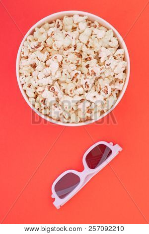 Paper Cup With Popcorn And 3d Glasses On Red Background, Top View. Flat Lay. Copyspace
