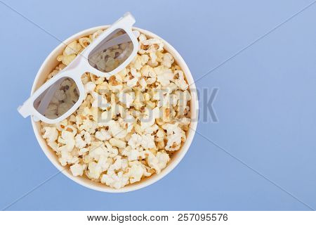 3d Glasses Lie On A Cup With Popcorn Isolated On A Pastel Blue Background. Cinema Concept. Flat Lay.