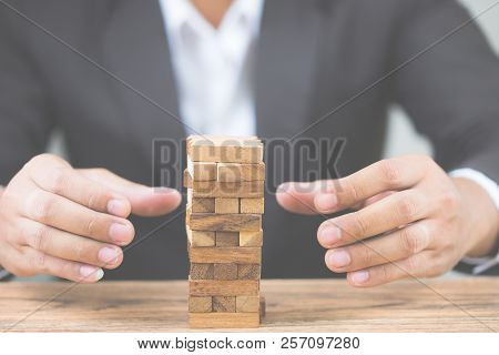 Businessman Hand Put Wood Blocks. Investment Risk And Uncertainty In The Real Estate Housing Market.