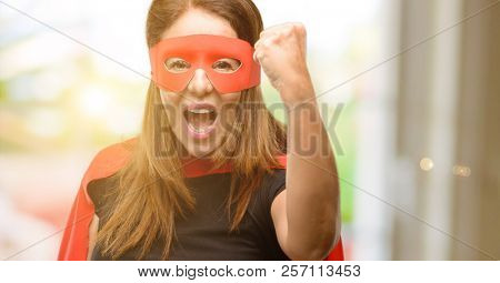 Middle age super hero woman wearing red mask and cape irritated and angry expressing negative emotion, annoyed with someone