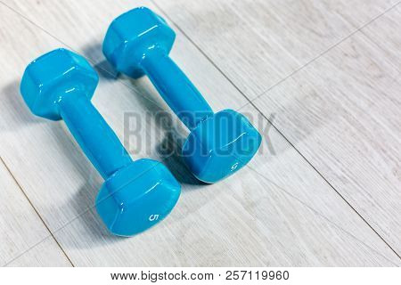 Blue Modern Dumbbells On A Wooden Floor