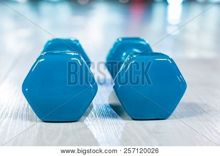 Blue Modern Dumbbells On A Wooden Floor