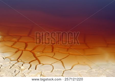Background - Cracked Clay Shore Of A Reservoir With Rusty Water