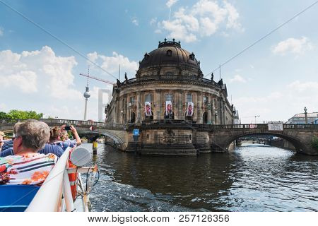 BERLIN, GERMANY - MAY 28, 2018: A view of the Spree River, with a tourist boat in the foreground and the Bode Museum in the background