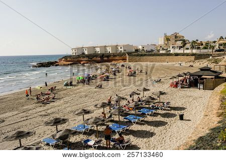 Torrevieja, Spain - Sept. 07 2018 :   Beach Loving Holiday Makers At Mosca Cala Playa.