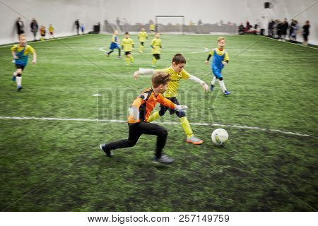 MOSCOW, RUSSIA - JAN 27, 2018: Forward and goalkeeper of children teams during children sport clubs cup soccer game at indoor sports ground of Krasnaya Presnya stadium.