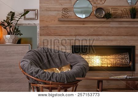 Cozy Living Room Interior With Comfortable Papasan Chair And Decorative Fireplace
