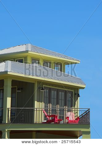 Oliva Casa costera con tumbonas rojo en balcón