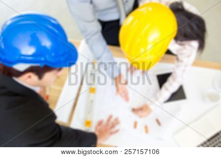 Blurred Phtograph Of A Group Of People Planing A Project Background.