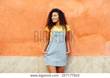 Smiling Arab Girl With Black Curly Hairstyle Looking Left Side. African Female In Casual Clothes In 