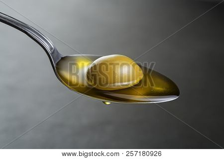 Spoon Of Virgin Olive Oil And Green Olive Close Up