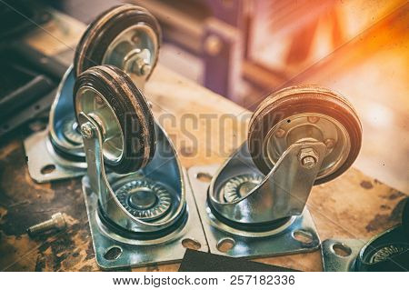Furniture Caster Wheel Made From Metal And Plastic On Wooden Table, Industrial Spinning Wheel.